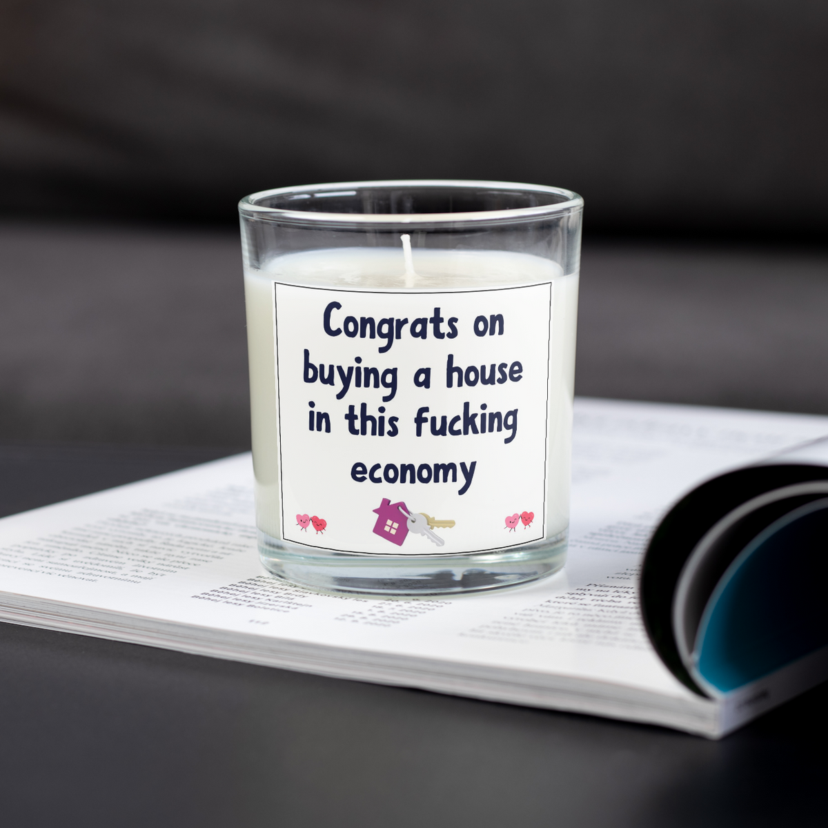 Funny sweary housewarming candle on an open magazine