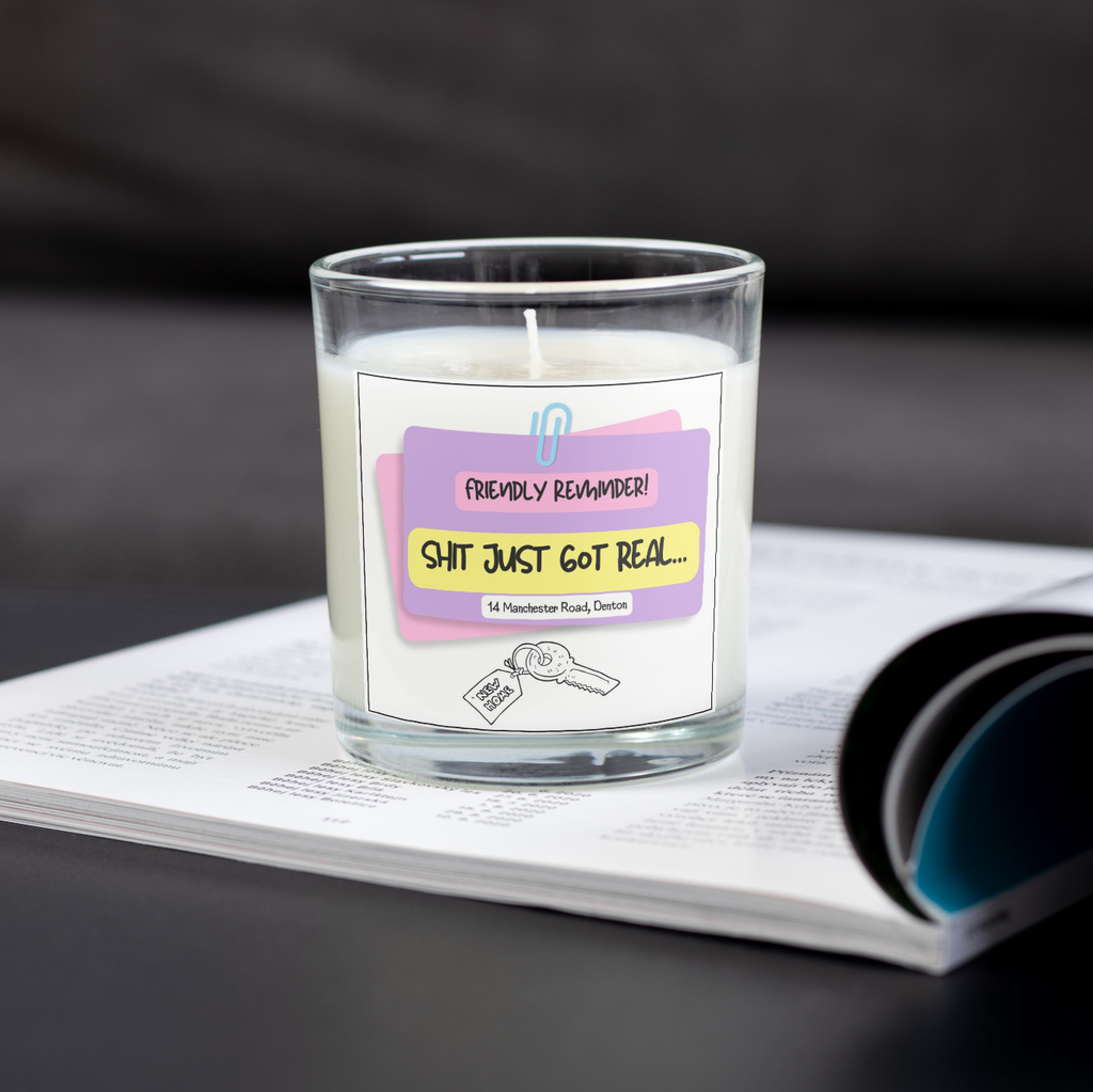 Shit Just Got Real personalised new home candle on an open magazine