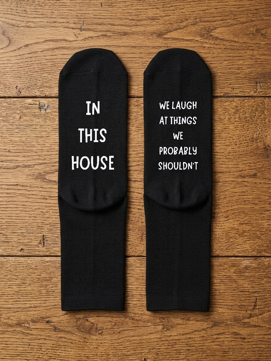 In This House We Laugh at Things Socks – Funny Gift – flat lay