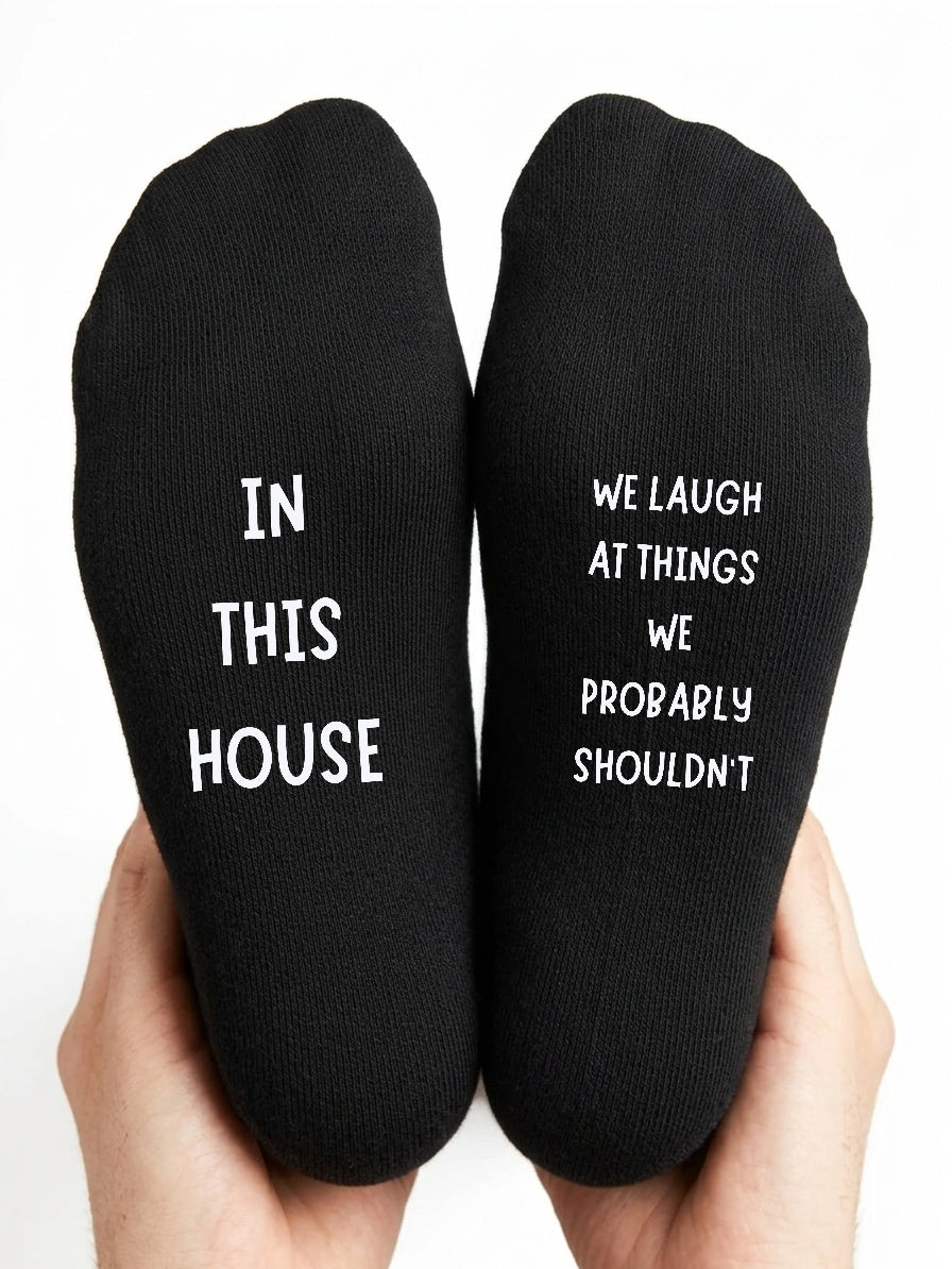 In This House We Laugh at Things Socks – Funny Gift – close-up of the wording