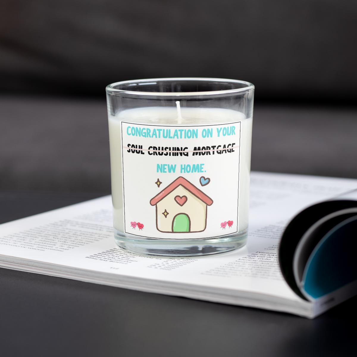 Soul crushing mortgage housewarming candle on an open magazine